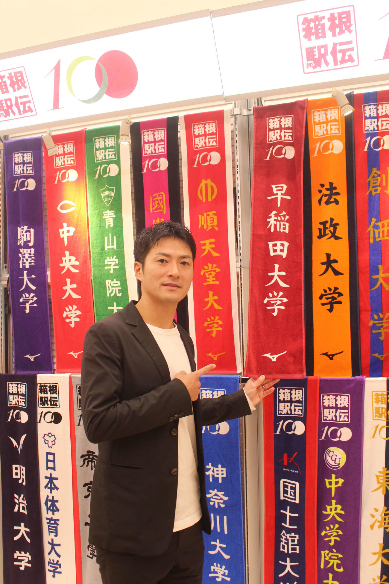 早稲田大学の応援タオルを持つ竹沢さん