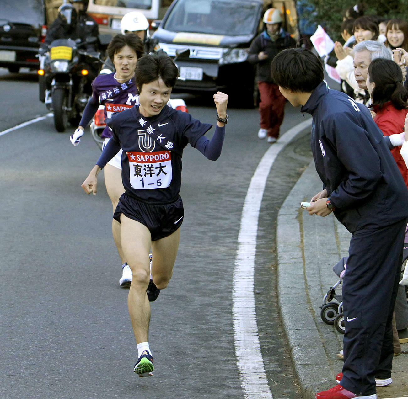 2010年1月2日、第86回箱根駅伝往路5区　明大・久国公也（後方）を抜きチームメートにガッツポーズを見せる東洋大・柏原竜二。6人抜きを達成し自身の持つ区間記録を更新。チームを往路優勝へと導いた