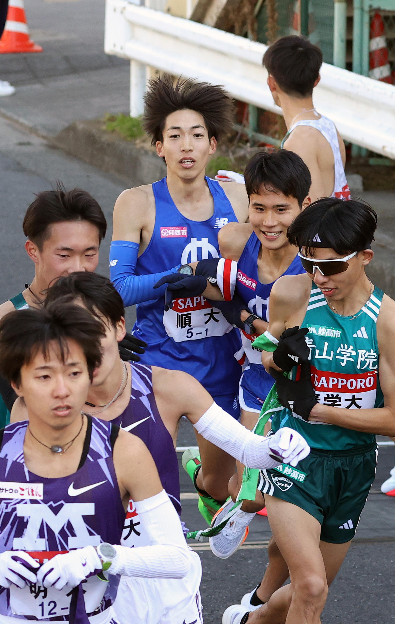 10位で順大2区浅井（中央右）にたすきを渡す1区三浦（中央）（撮影・大野祥一）