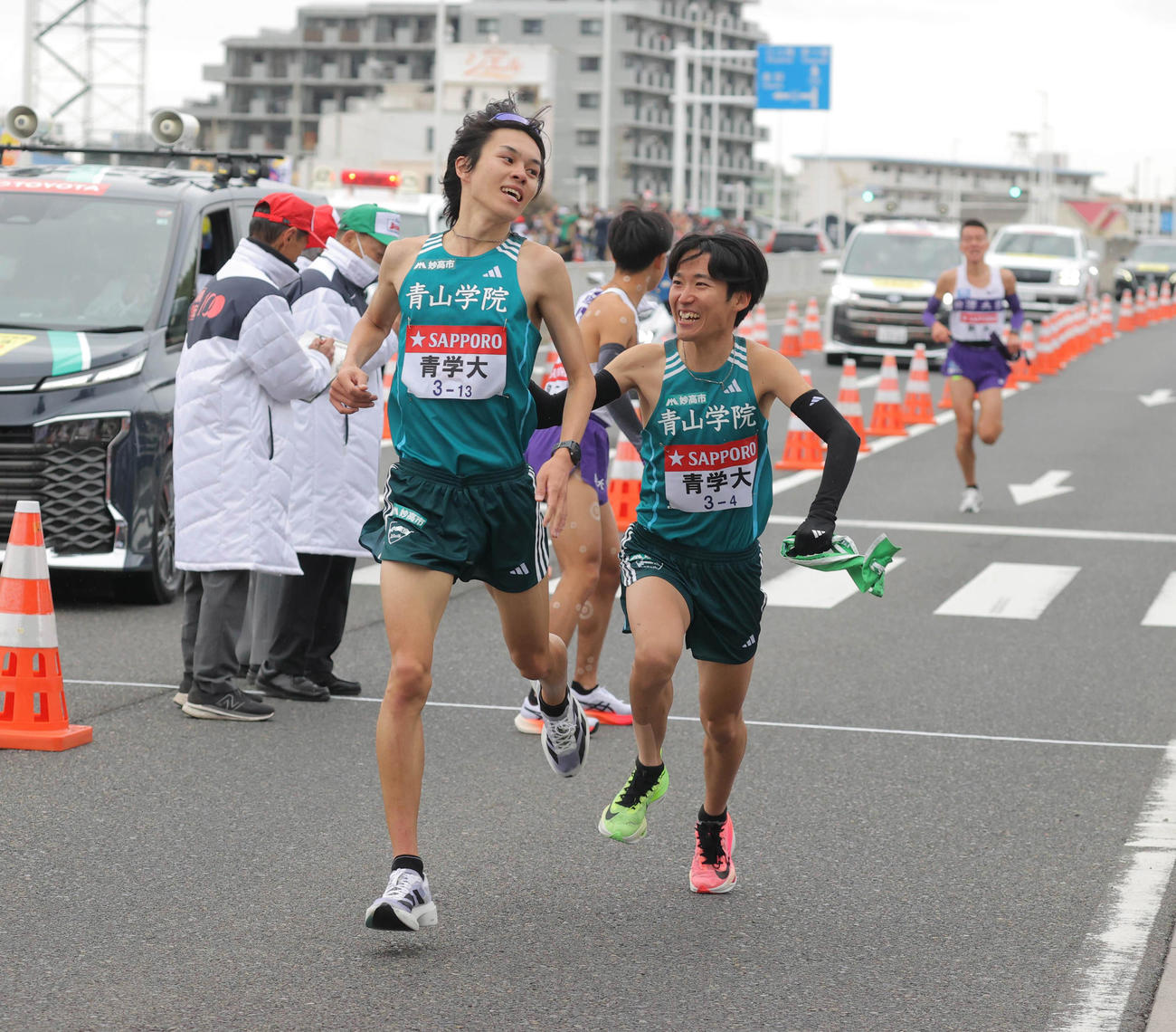 平塚中継所トップでタスキをつなぐ青学大3区の太田（左）と4区の佐藤（代表撮影）