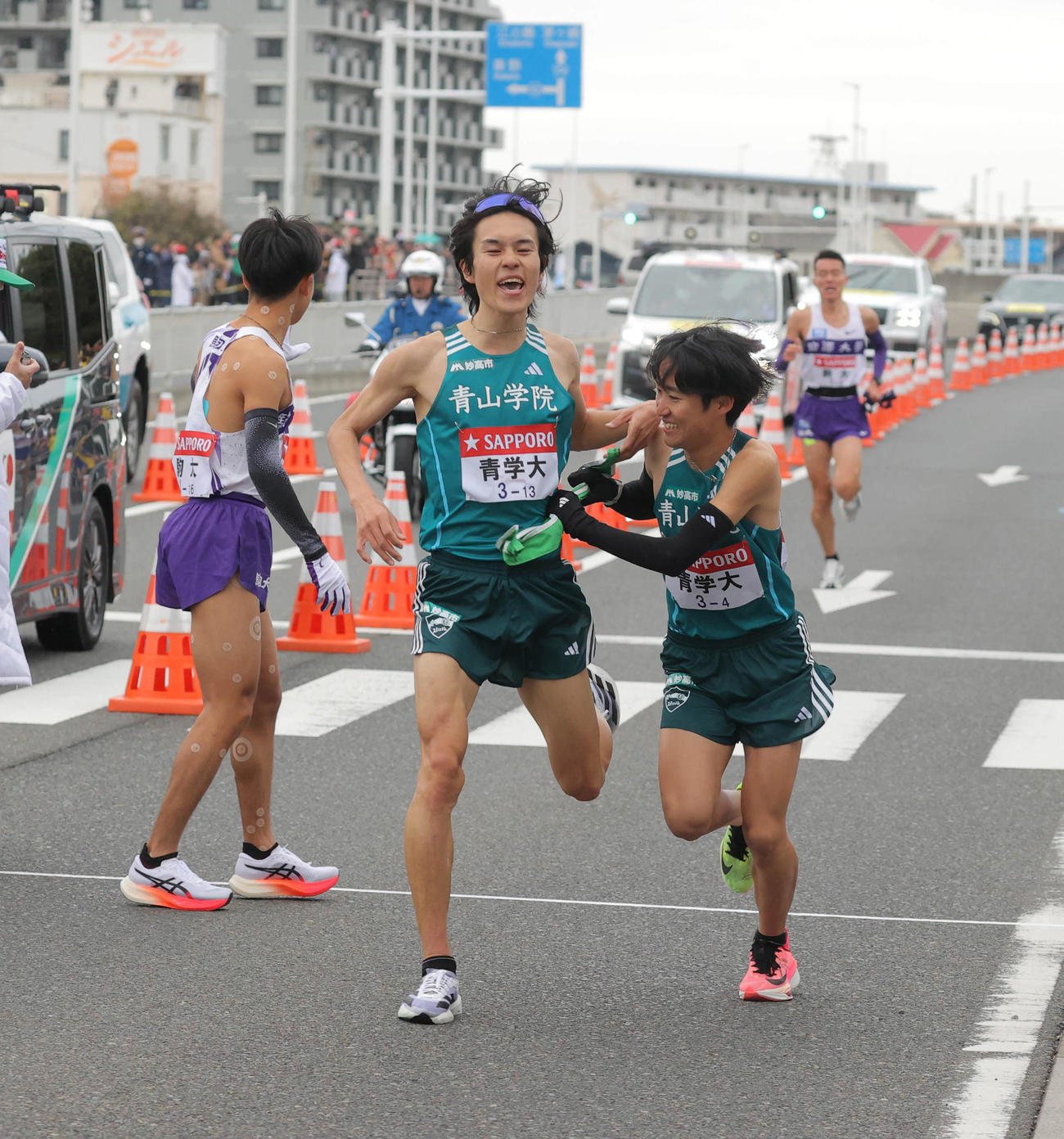 平塚中継所トップでタスキをつなぐ青学大3区の太田（左）と4区の佐藤（代表撮影）