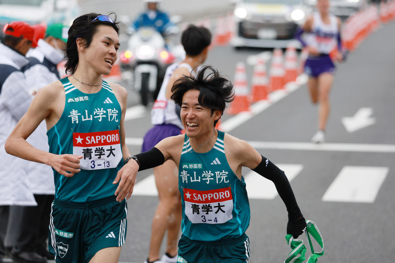 平塚中継所でたすきをつなぐ青学大3区の太田（左）と4区の佐藤（代表撮影）