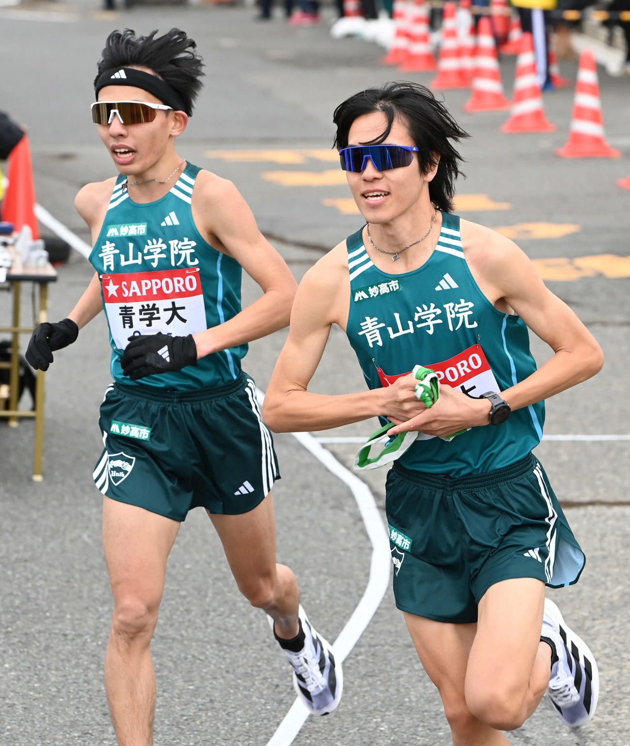 戸塚中継所から駆け出す青学大3区太田生。左は2区黒田（撮影・山崎安昭）