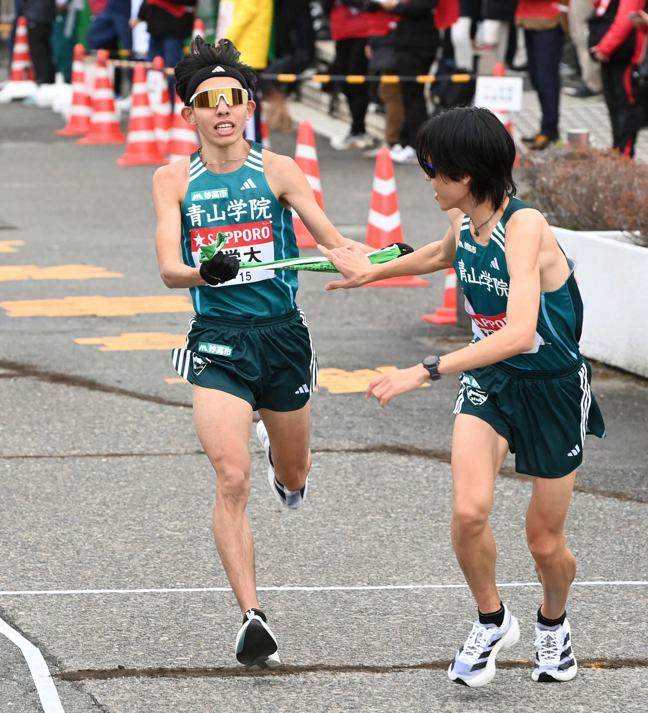 戸塚中継所で青学大2区黒田（左）は3区太田にたすきを渡す（撮影・山崎安昭）