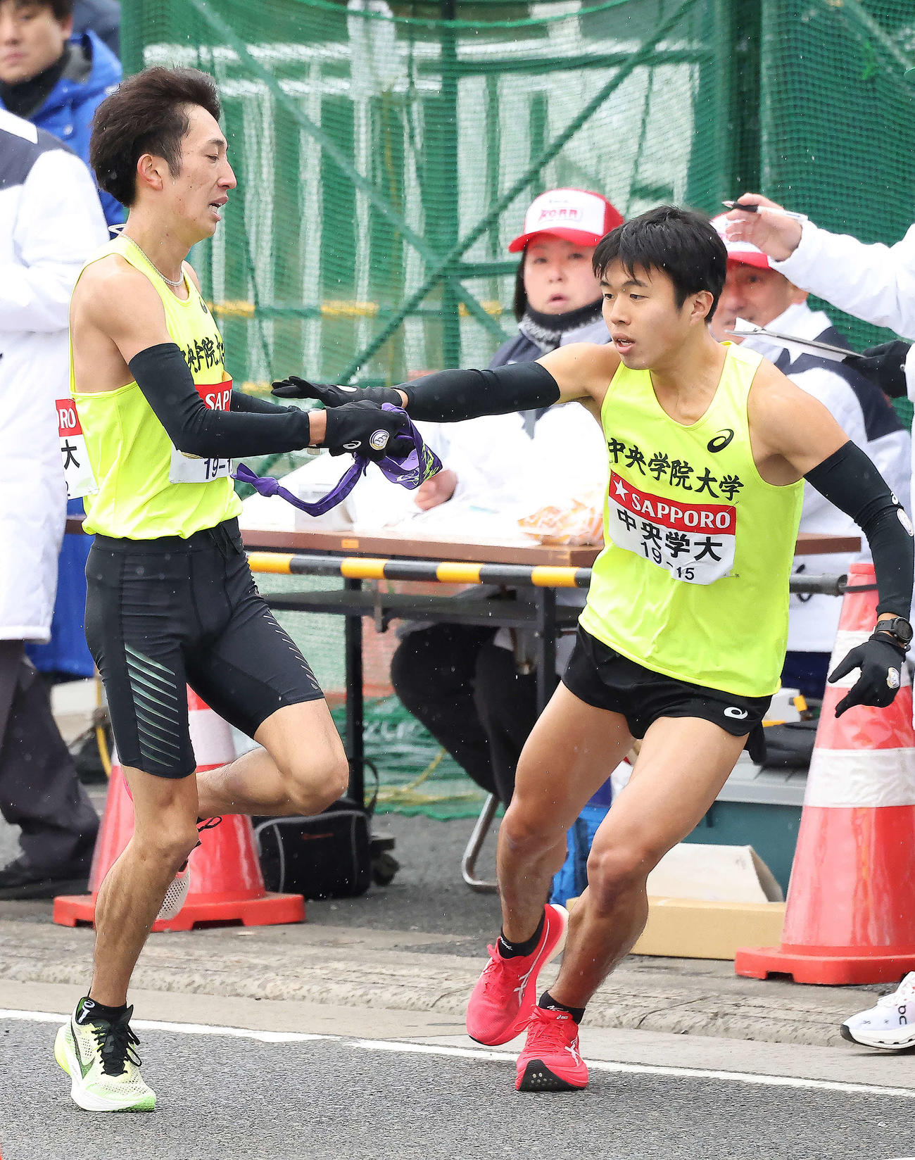 平塚中継所、中央学院大3区伊藤（左）は20位で4区黒岩にたすきを渡す（撮影・河田真司）