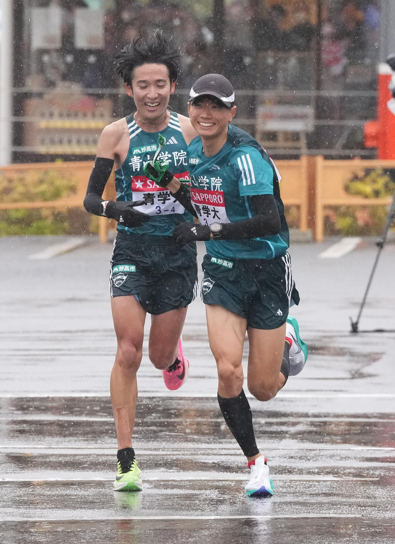 青学大4区佐藤（左）は小田原中継所で5区若林にたすきを渡す（撮影・鈴木みどり）