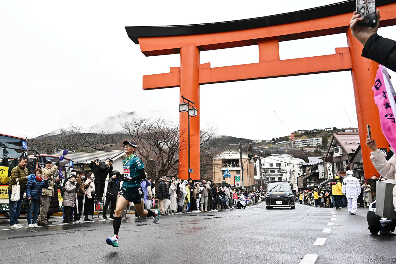 箱根神社の大鳥居をトップで走り抜ける青学大5区若林（撮影・滝沢徹郎）