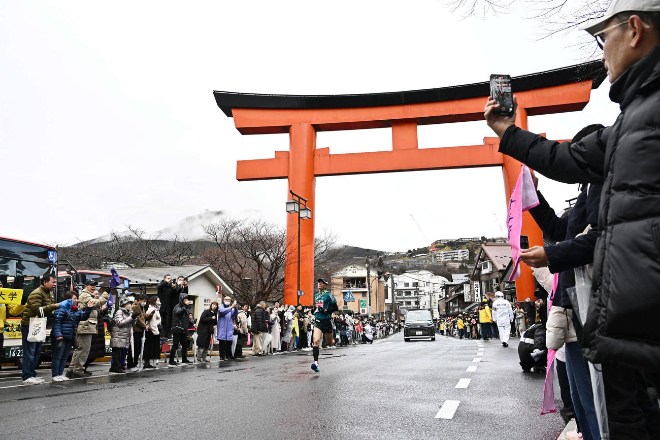 箱根神社の大鳥居をトップで走り抜ける青学大5区若林（撮影・滝沢徹郎）