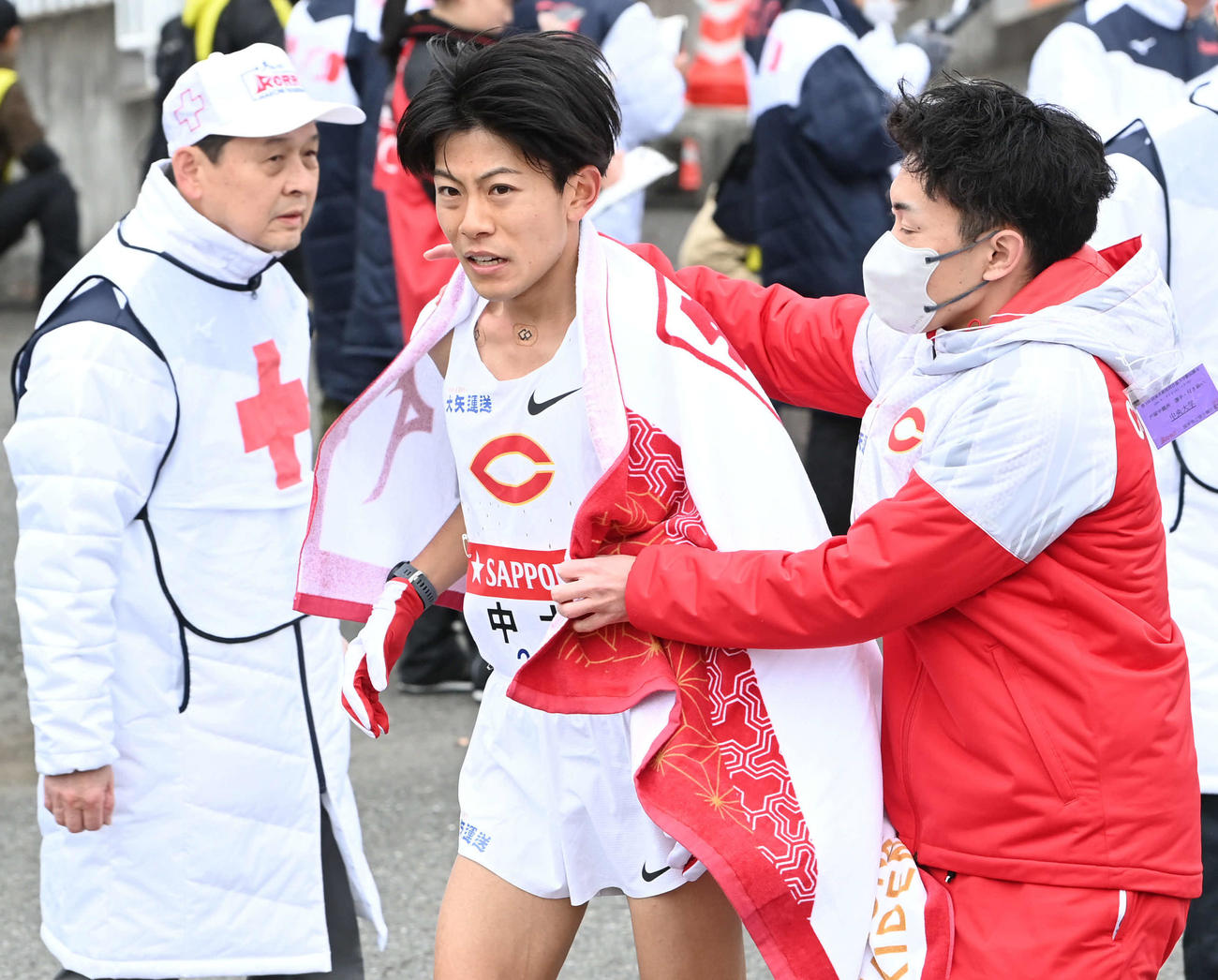 戸塚中継所にゴールした中大2区吉居（中央）はチームメートに迎えられる（撮影・山崎安昭）