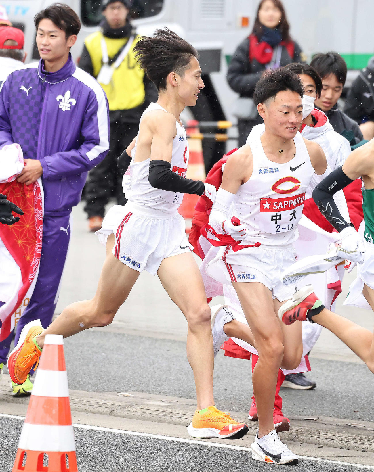 平塚中継所、中大3区中野（左）は18位で4区湯浅にたすきを渡す（撮影・河田真司）