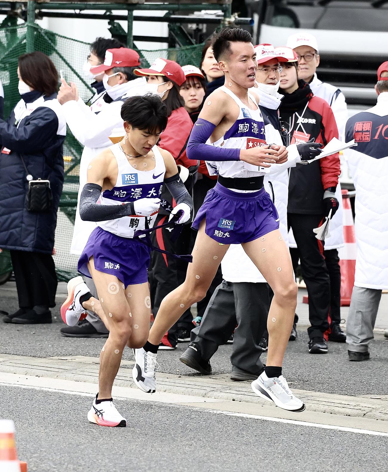 平塚中継所、駒大3区佐藤（右）は2位で4区山川にたすきを渡す（撮影・河田真司）