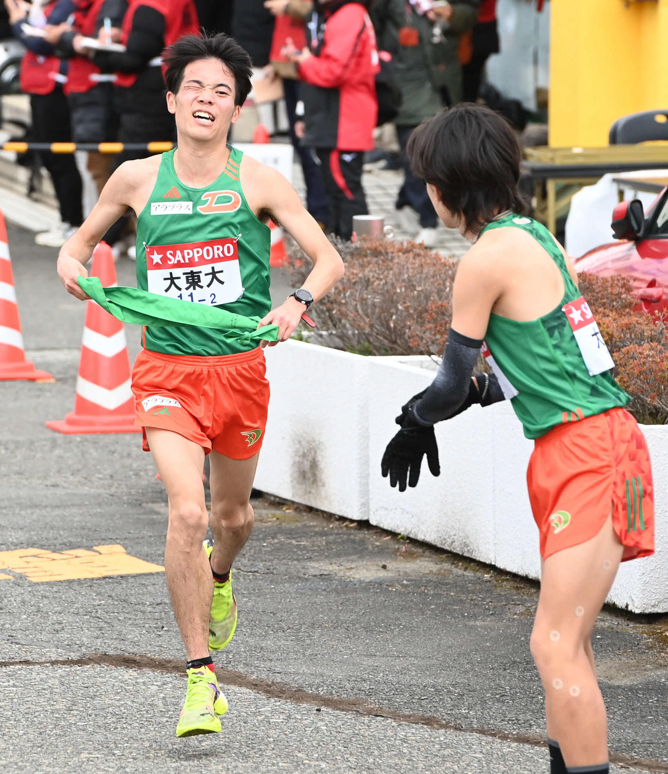 大東大2区久保田（左）は3区入浜にたすきを渡す（撮影・山崎安昭）