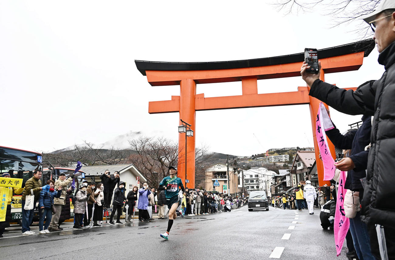 箱根神社の大鳥居をトップで走り抜ける青学大5区若林（撮影・滝沢徹郎）