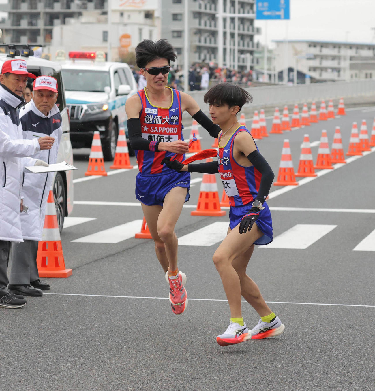 平塚中継所でタスキをつなぐ創価大3区の山森（左）と4区の野沢（代表撮影）