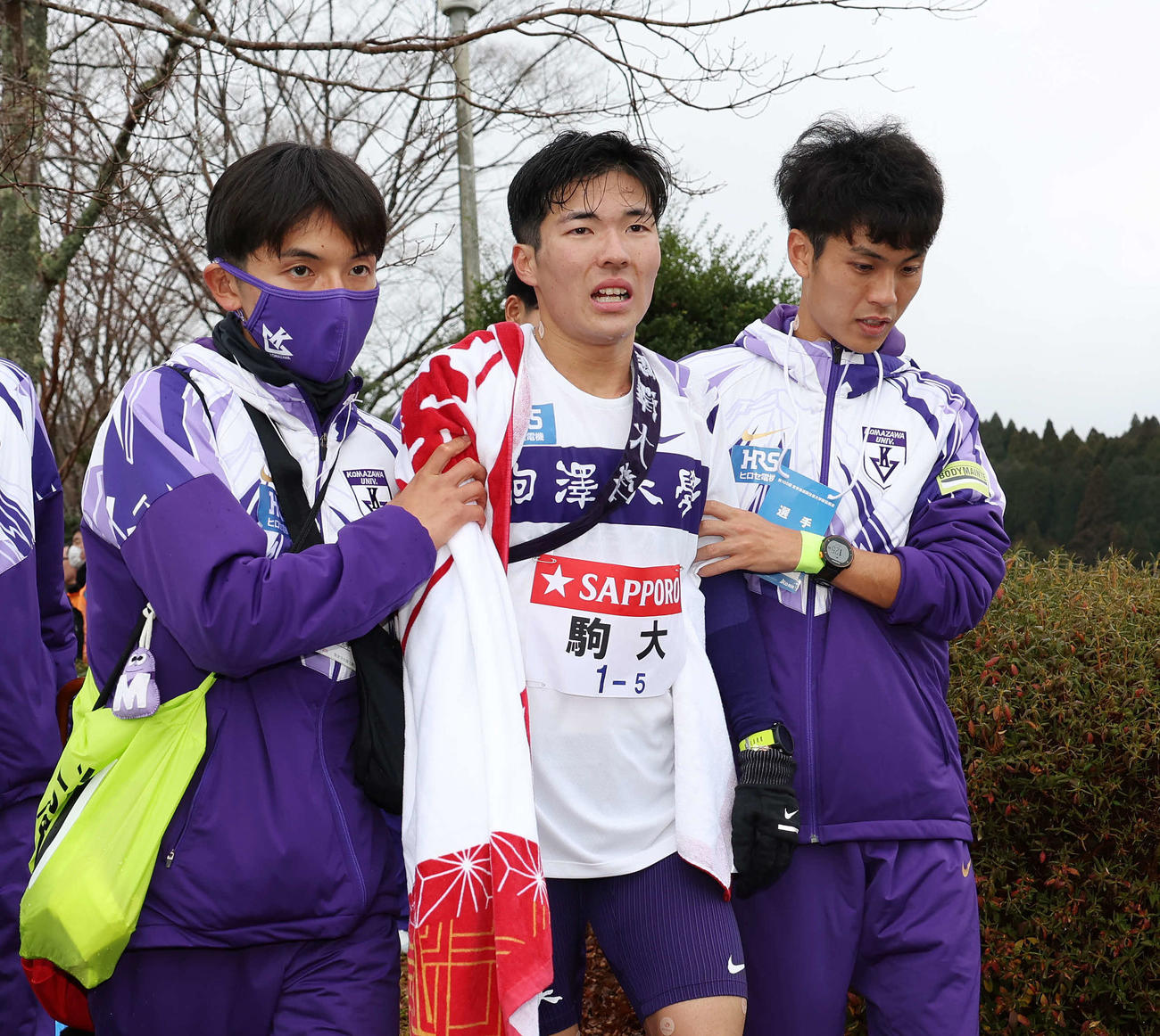 往路を2位でゴールし、仲間に支えられながら厳しい表情の駒大5区金子（中央）（撮影・宮地輝）