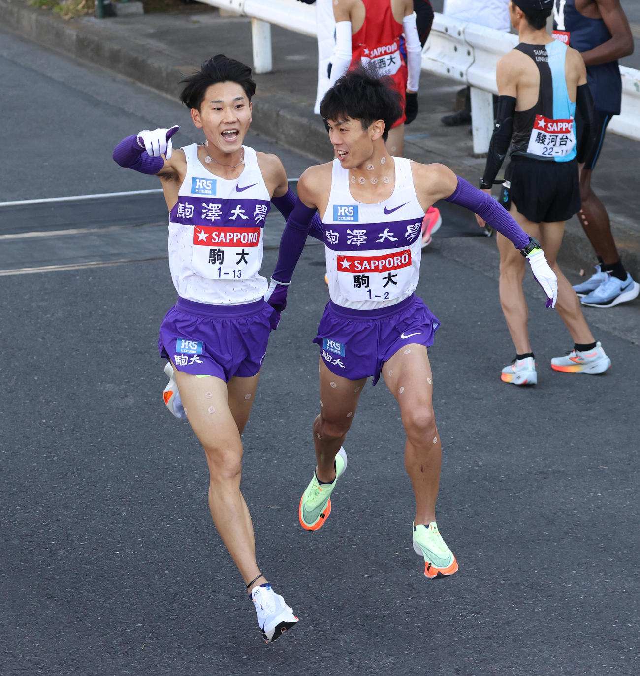 箱根駅伝　駒大1区篠原（左）は2区鈴木にたすきを渡す（撮影・大野祥一）