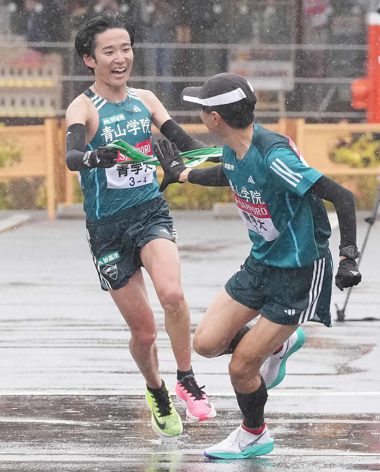 青学大4区佐藤（左）は小田原中継所で5区若林にたすきを渡す（撮影・鈴木みどり）