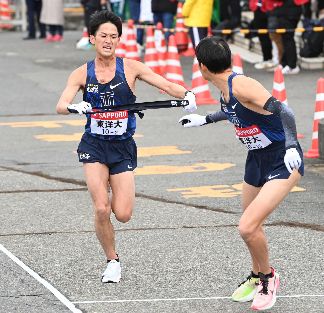 東洋大2区梅崎（左）は3区小林にたすきを渡す（撮影・山崎安昭）