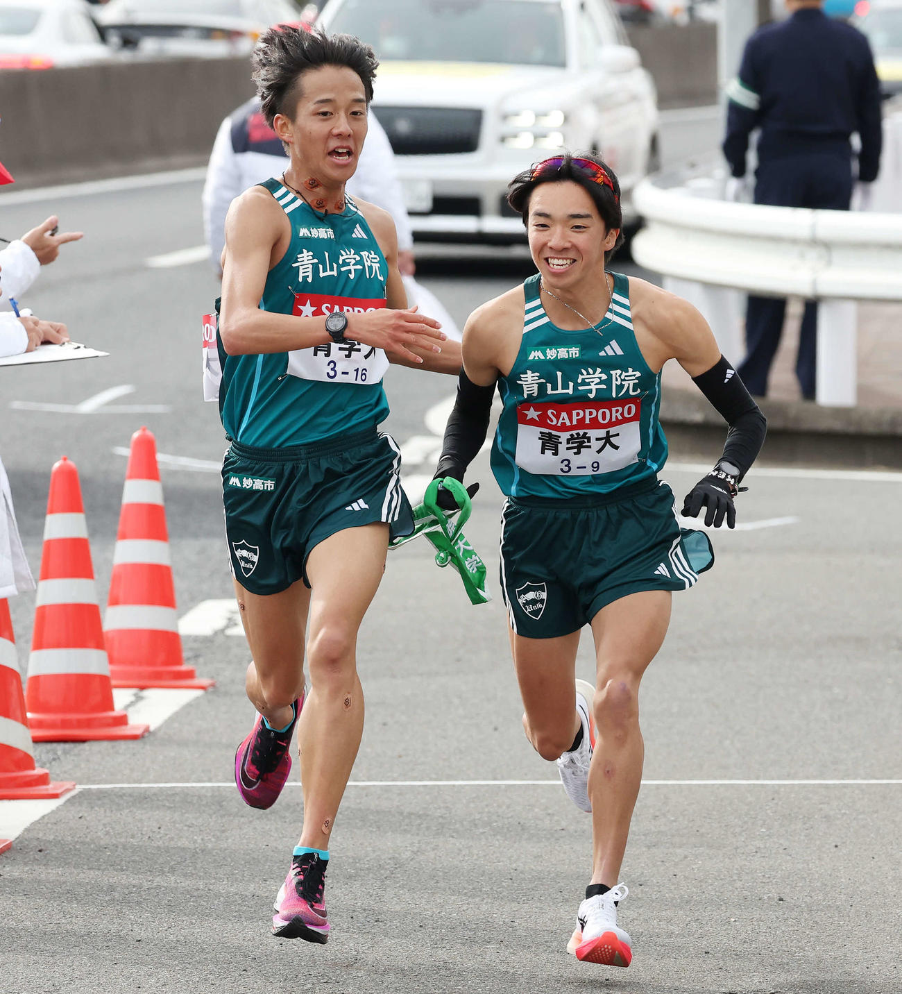 青学大8区塩出（左）は戸塚中継所をトップで9区倉本にタスキをつなぐ（撮影・宮地輝）