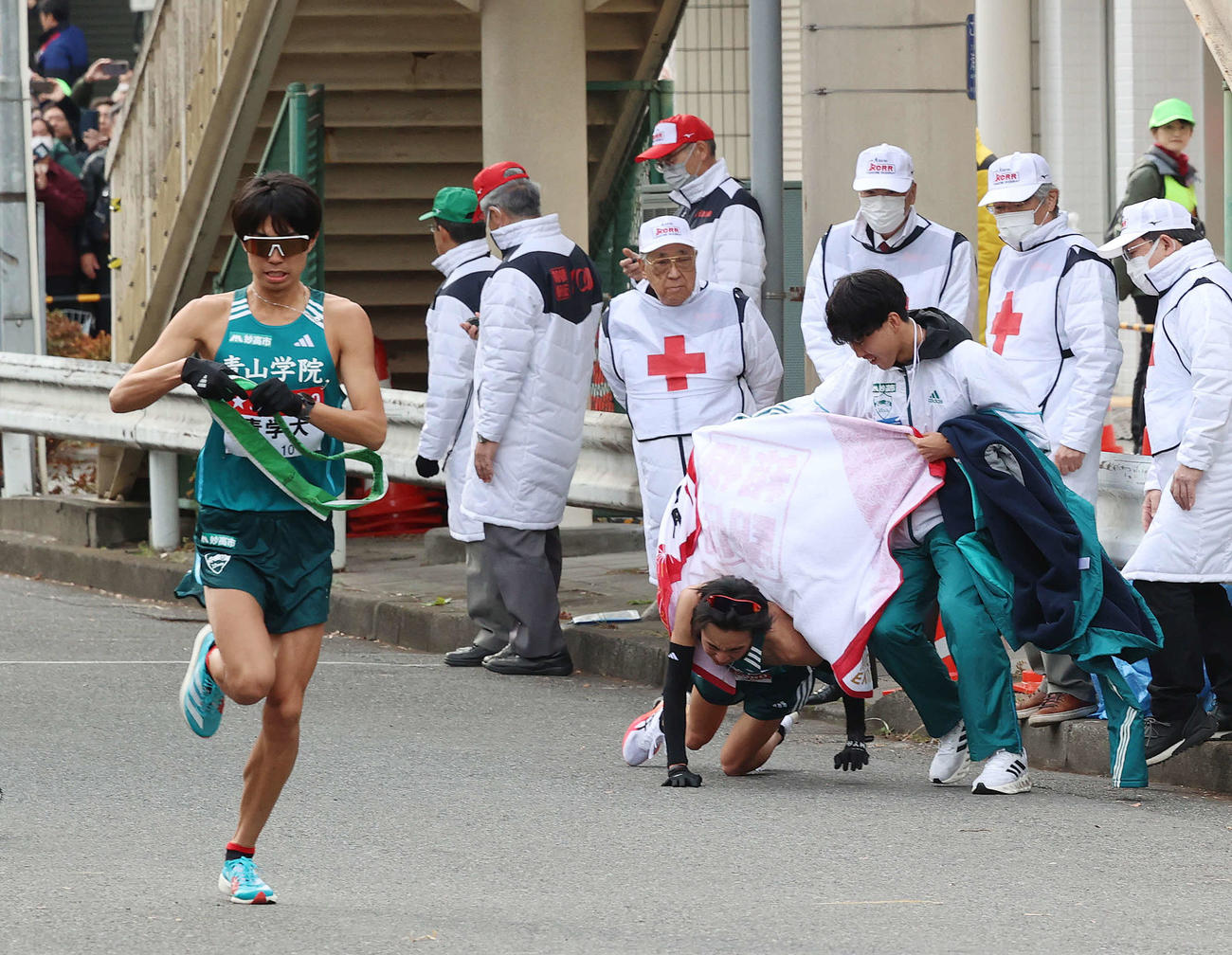 鶴見中継所で10区の青学大・宇田川（左）にたすきをつないで倒れ込む倉本（右下）（撮影・河野匠）