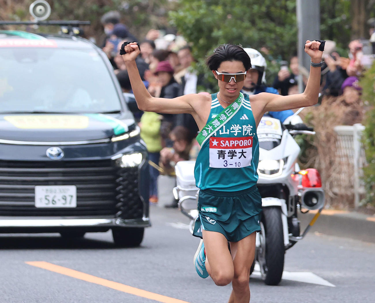 10区、後方を走る運営管理車の青学大・原監督から声をかけられ、両手を挙げて応える宇田川（撮影・河野匠）