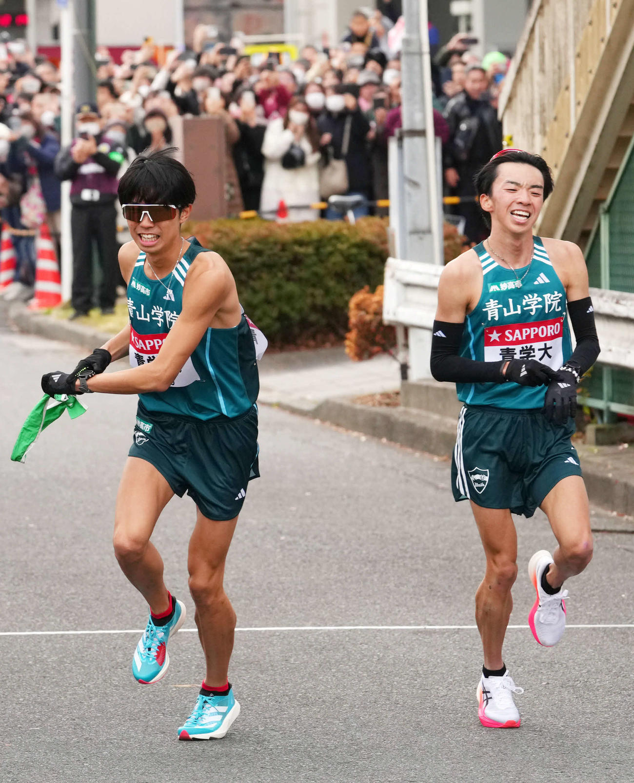 鶴見中継所で10区宇田川（左）にたすきを渡す青学大9区倉本（撮影・横山健太）