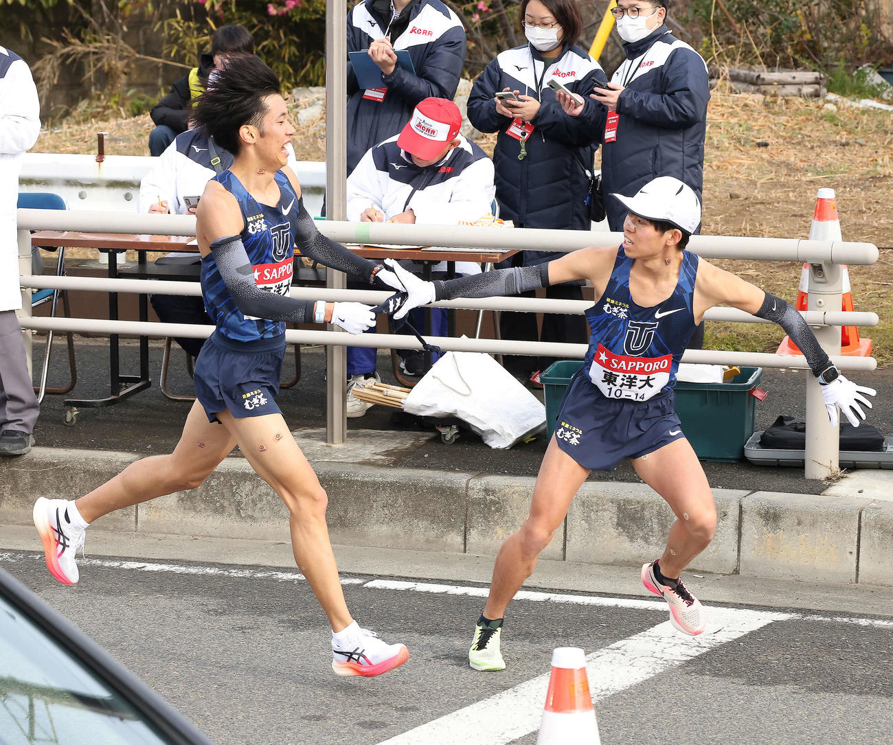 平塚中継所、東洋大7区熊崎（左）は5位で8区村上にたすきを渡す（撮影・河田真司）