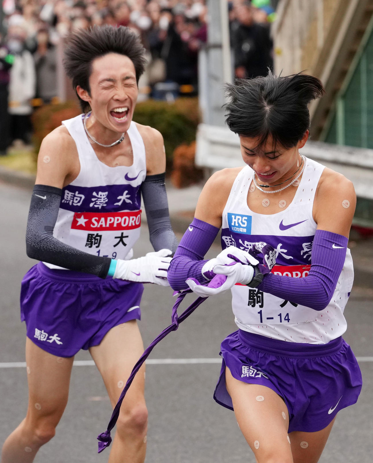 鶴見中継所で駒大9区花尾恭輔（左）からタスキを受け走り出す10区庭瀬（撮影・横山健太）