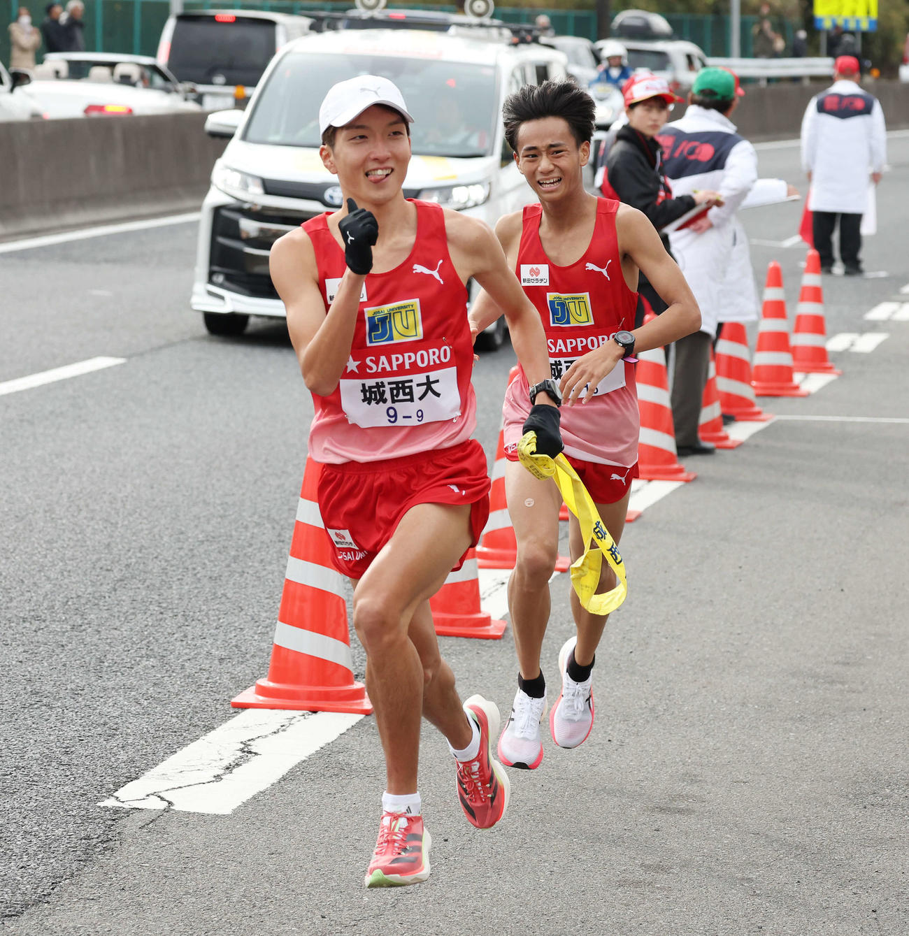 戸塚中継所で城西大8区小田（右）からタスキを受け取り、さっそうと駆け出す9区平林（撮影・宮地輝）