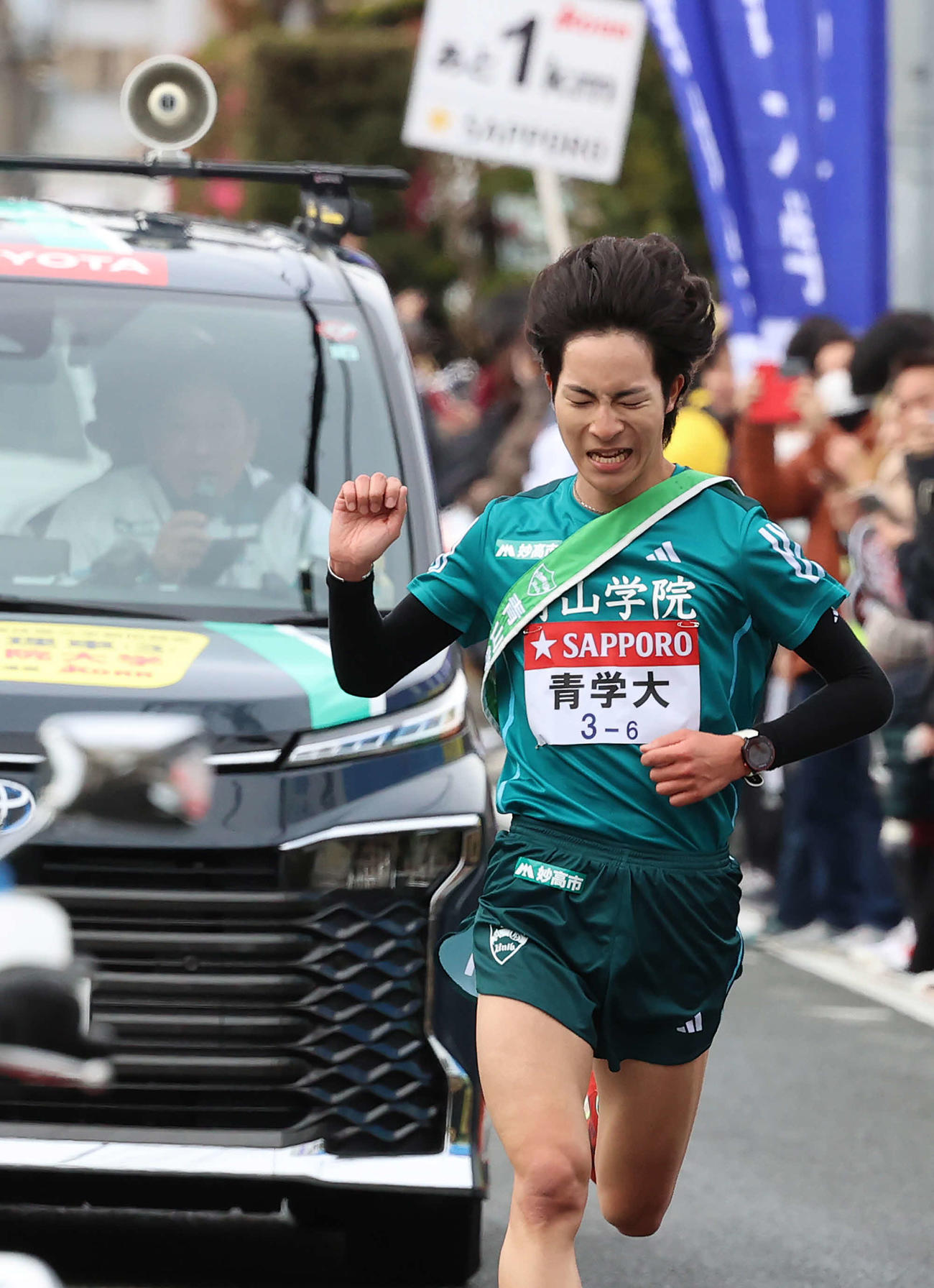 6区、ラスト1キロ地点で青学大・原監督（後方）に声をかけられ手を挙げて応える野村（撮影・河野匠）