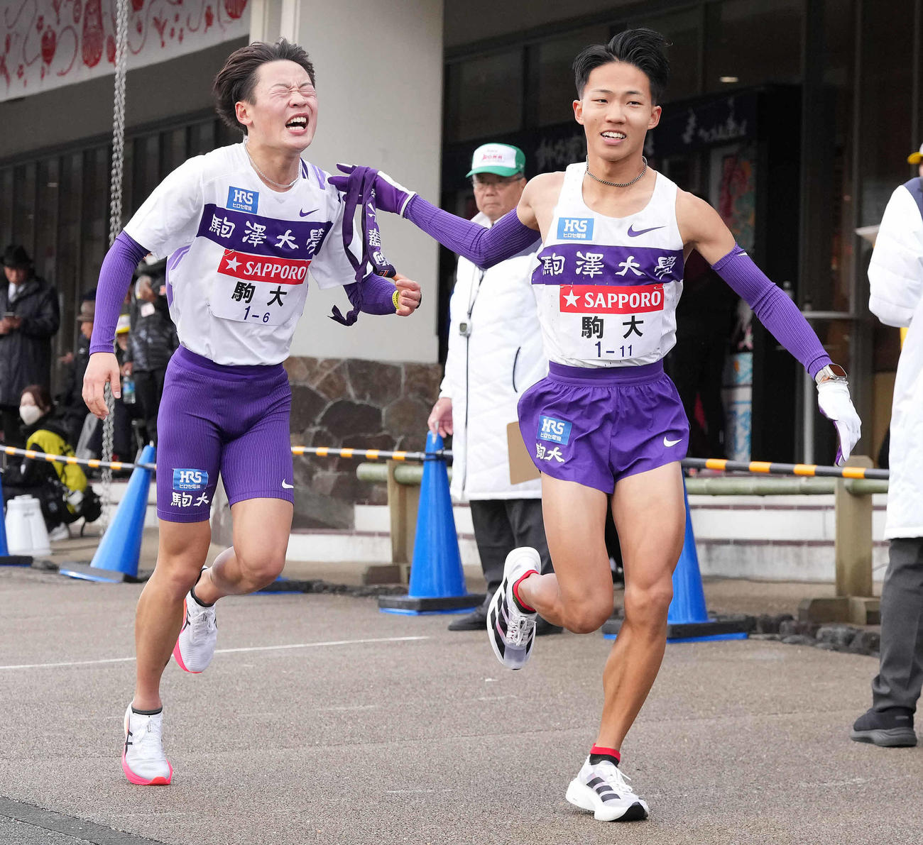 小田原中継所で7区安原（右）にたすきを渡す駒大6区帰山（撮影・鈴木みどり）