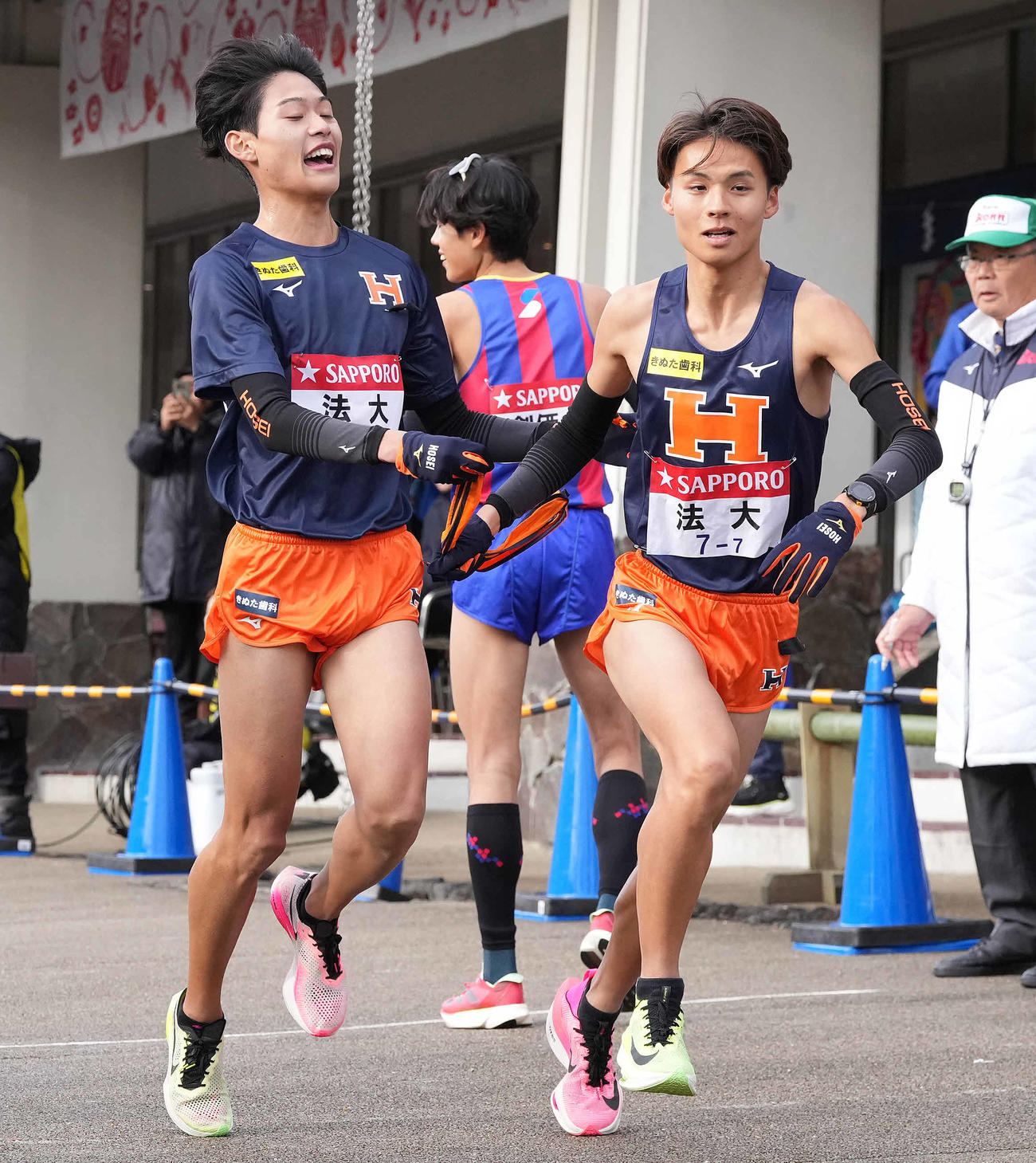 小田原中継所で7区矢原（右）にたすきを渡す法大6区武田（撮影・鈴木みどり）