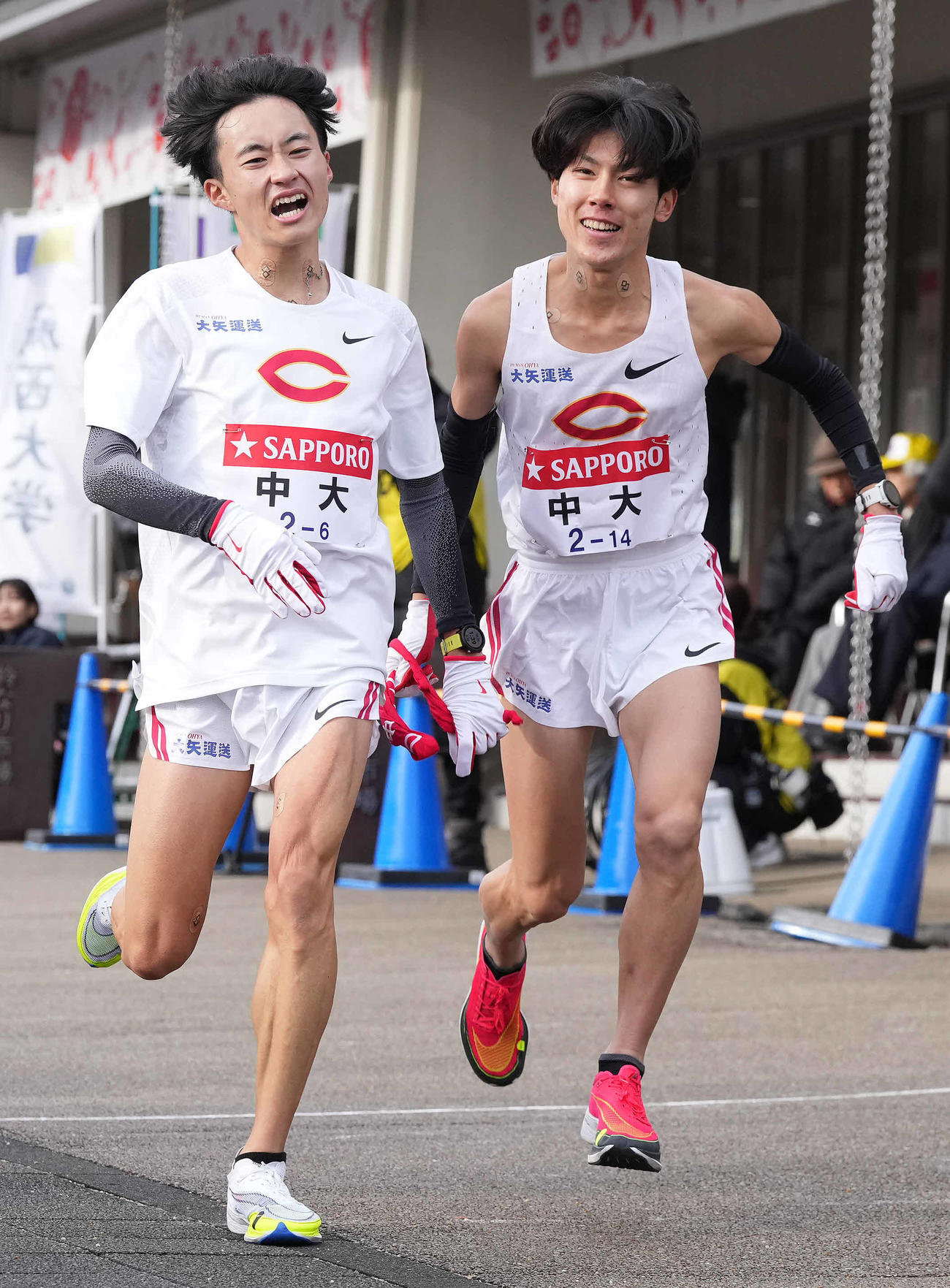 小田原中継所で7区吉居（右）にたすきを渡す中大6区浦田（撮影・鈴木みどり）