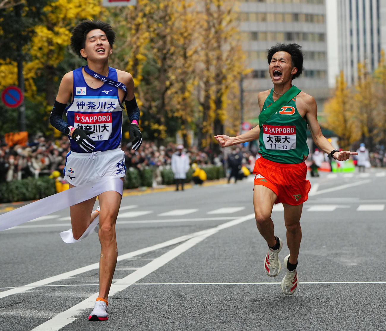 笑顔でゴールする大東大10区佐々木（右）と神奈川大10区酒井（撮影・垰建太）