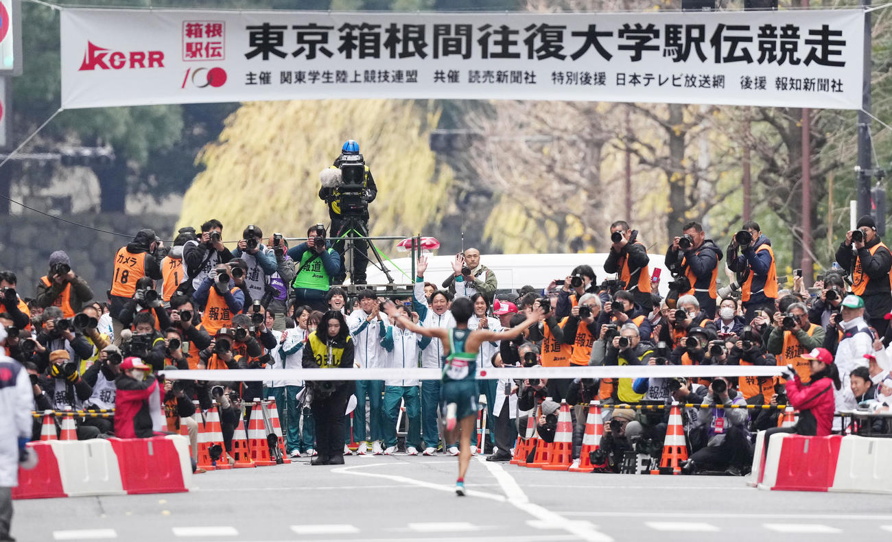 1位でゴールする10区宇田川（手前）を迎える青学大・原監督（中央）ら選手たち（撮影・菅敏）