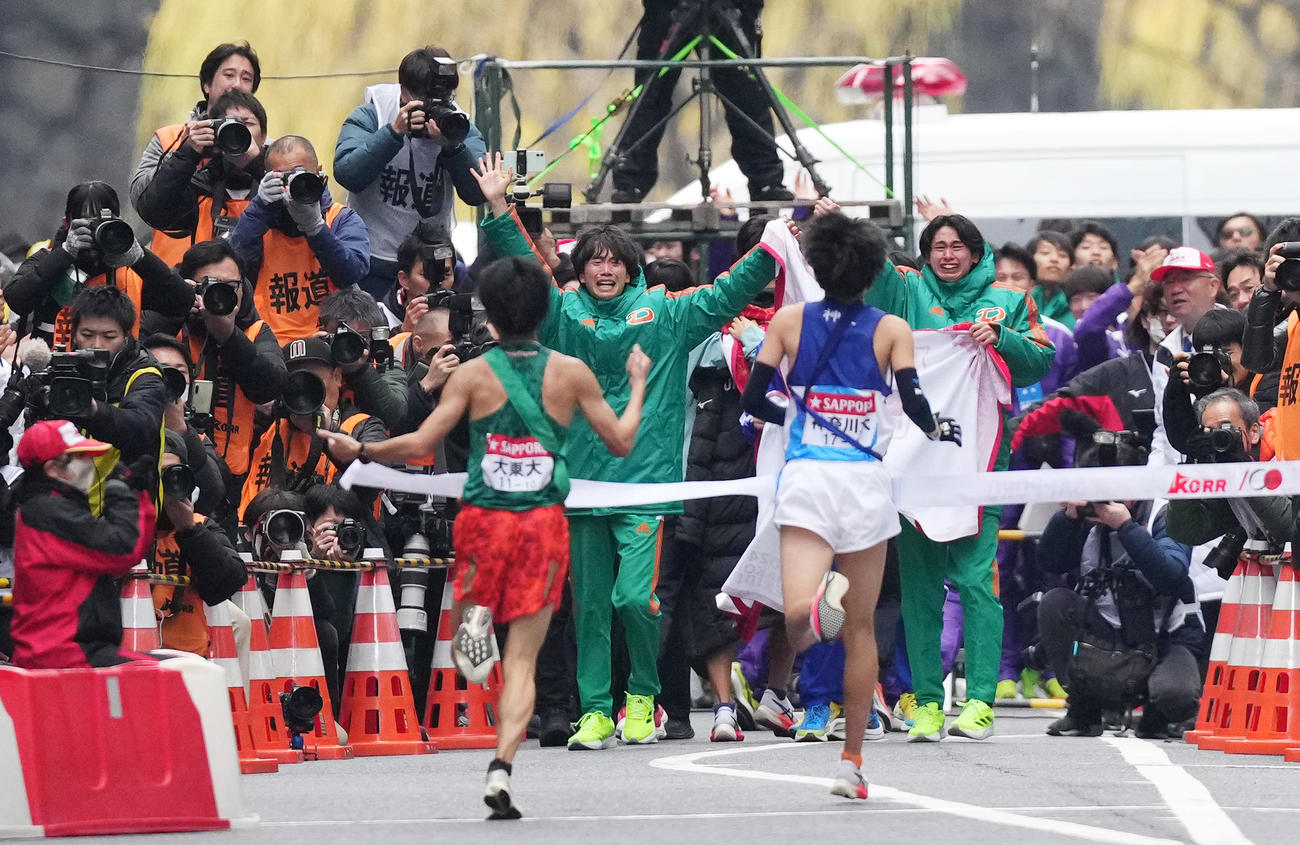 大東大10区佐々木（左）は、チームメートに迎えられ、総合10位でゴールをする（撮影・菅敏）