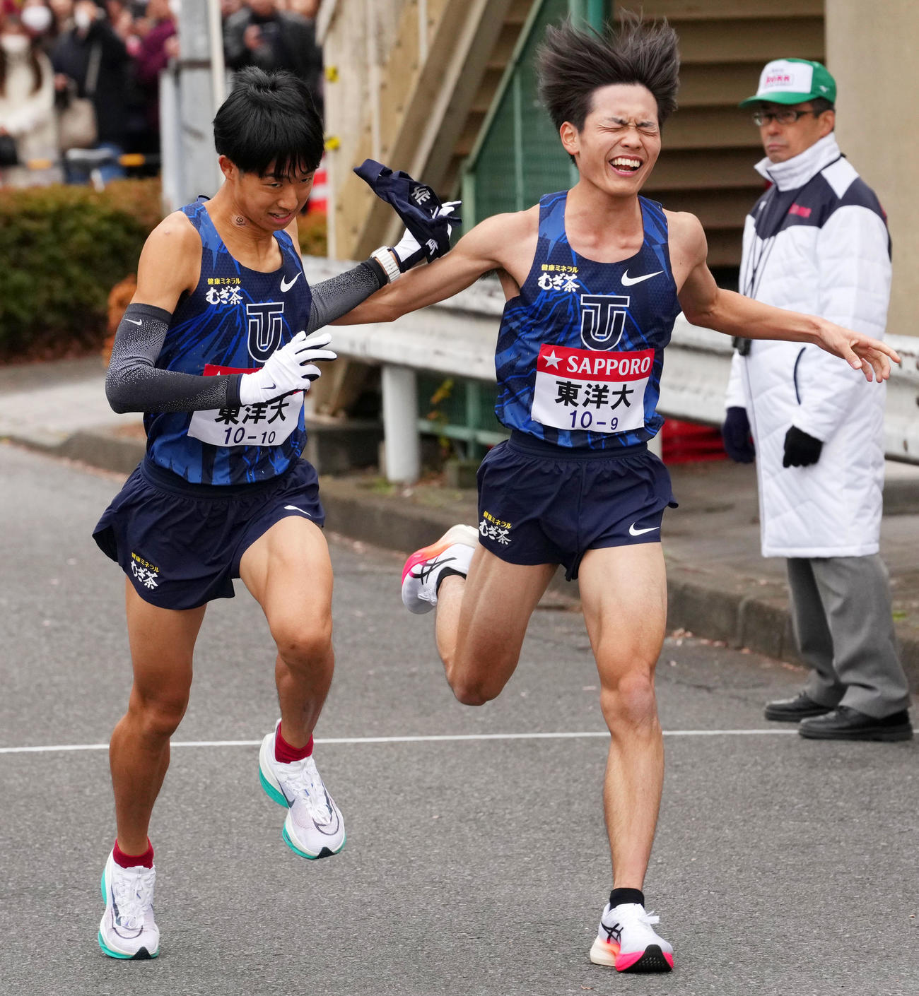 鶴見中継所で10区岸本（左）にたすきを渡す東洋大9区吉田（撮影・横山健太）