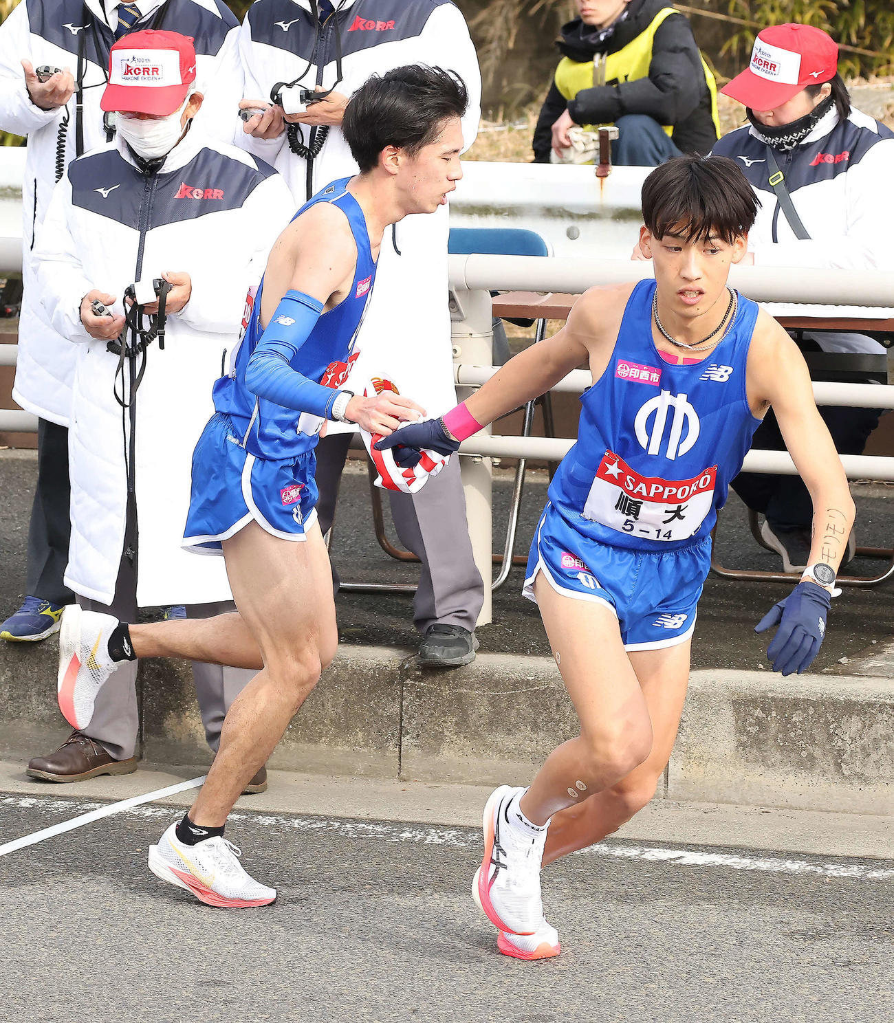 平塚中継所、順大7区内田（左）は21位で8区森本（撮影・河田真司）