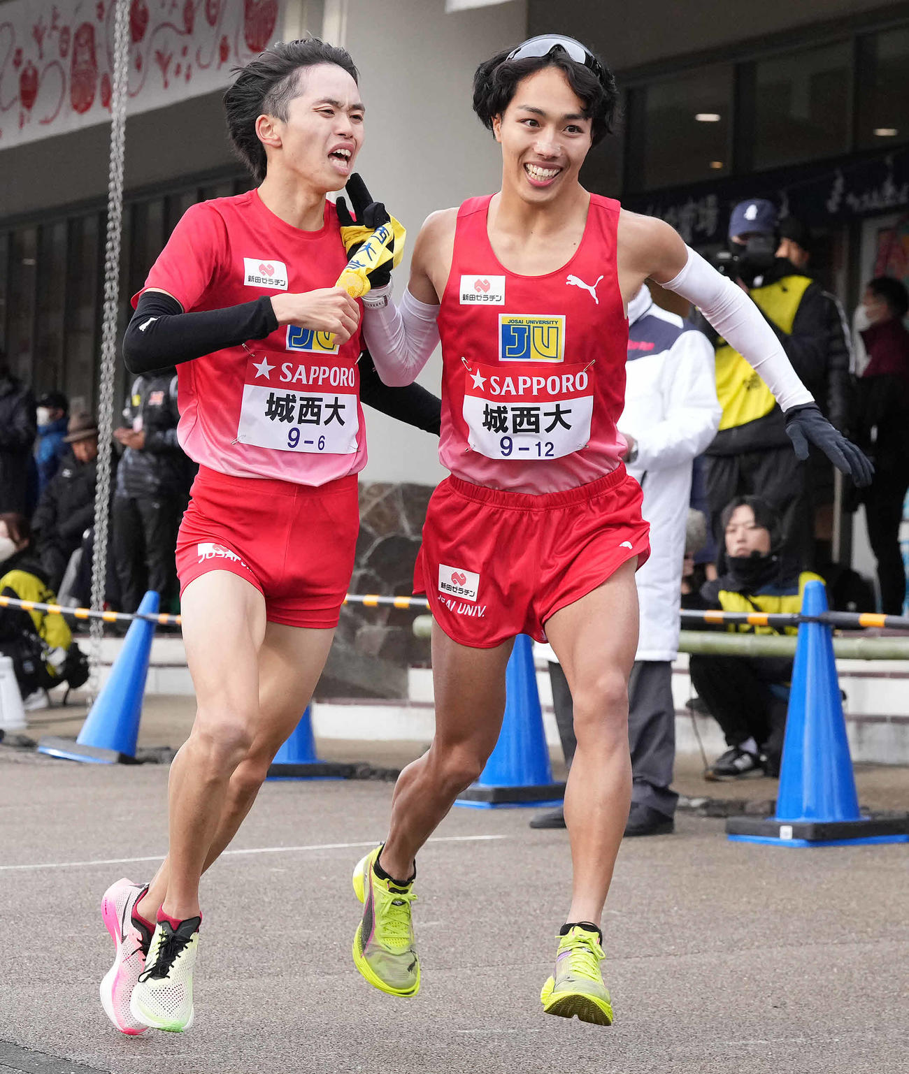 小田原中継所で7区林（右）にたすきを渡す城西大6区久保（撮影・鈴木みどり）