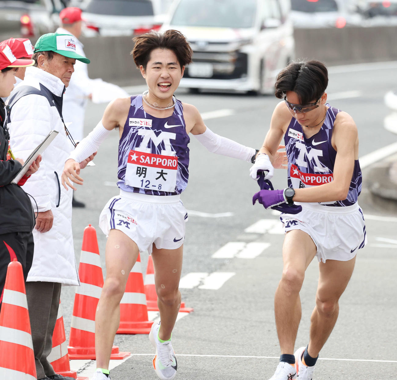 戸塚中継所で明大8区綾（左）は9区鈴木にタスキをつなぐ（撮影・宮地輝）