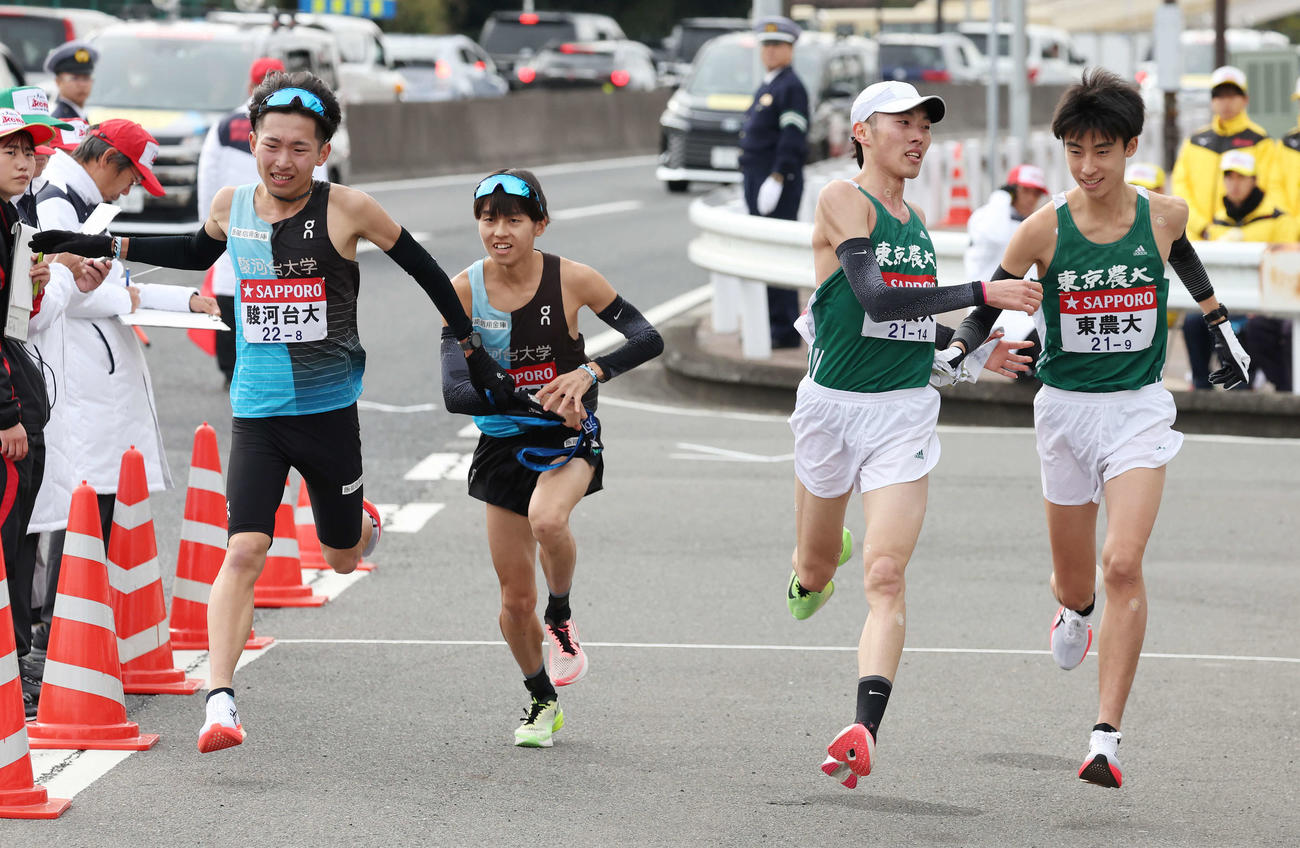 戸塚中継所でタスキをつなぐ、左から駿河台大8区岡崎、9区長田、東農大8区円谷、9区深堀（撮影・宮地輝）