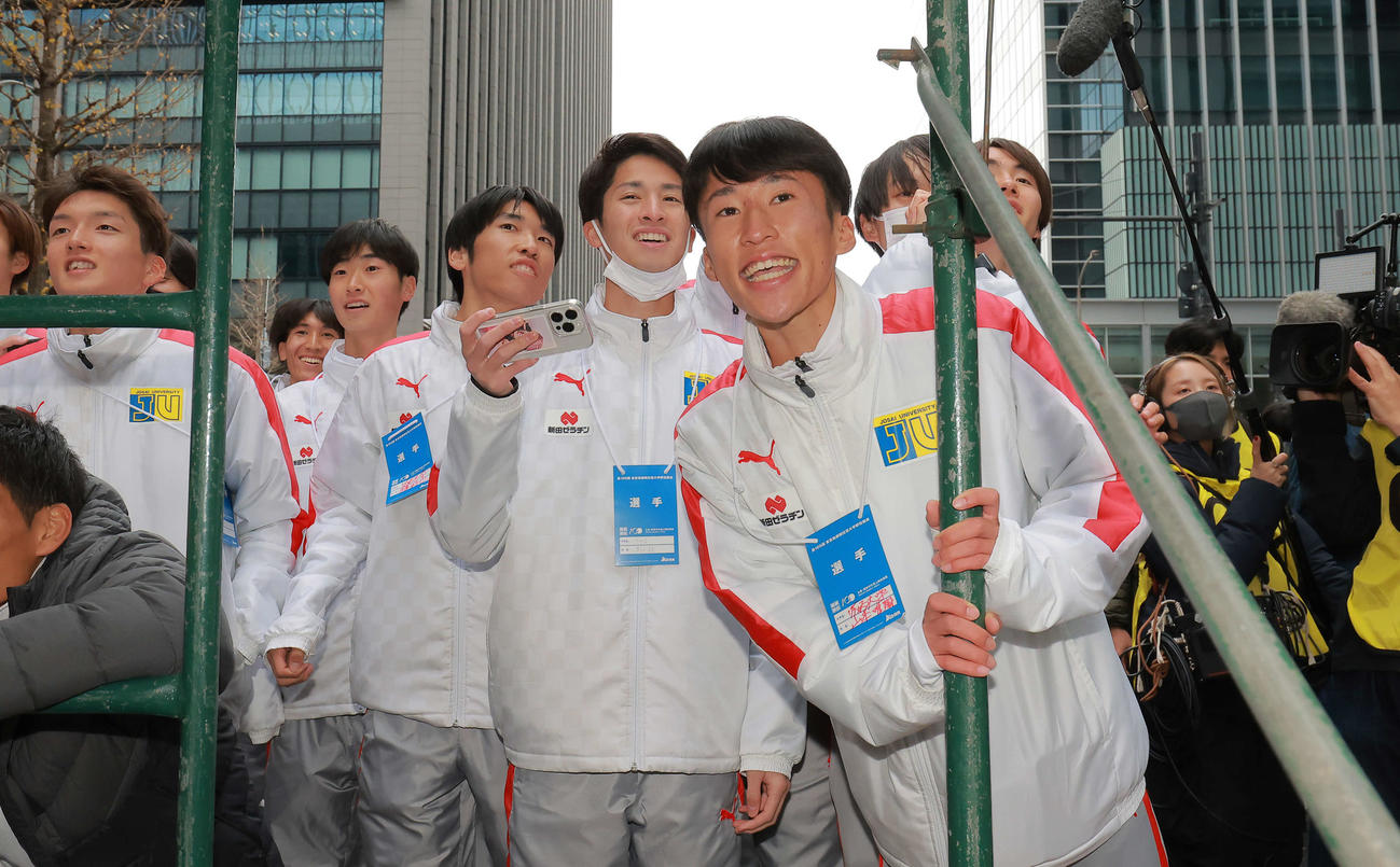 3位でゴールに向かう城西大10区の中田を応援する山本（右手前）と選手たち（代表撮影）