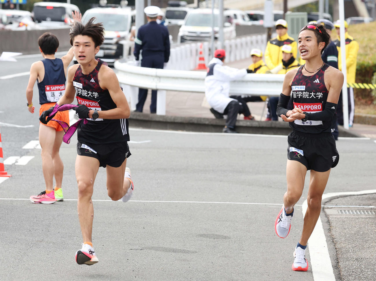 国学院大8区鎌田（右）は戸塚中継所を5位で9区吉田にタスキをつなぐ（撮影・宮地輝）