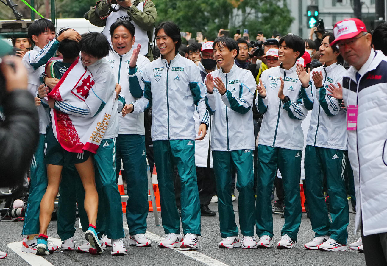 優勝のゴールテープを切った青学大10区宇田川（左から2人目）を笑顔で出迎える原監督（同4人目）ら選手たち（撮影・垰建太）
