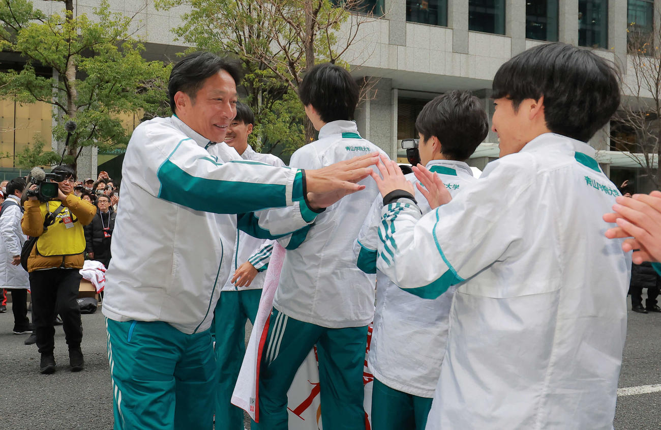 青学大・原監督（左）がゴールに到着し選手とタッチを交わして喜ぶ（代表撮影）