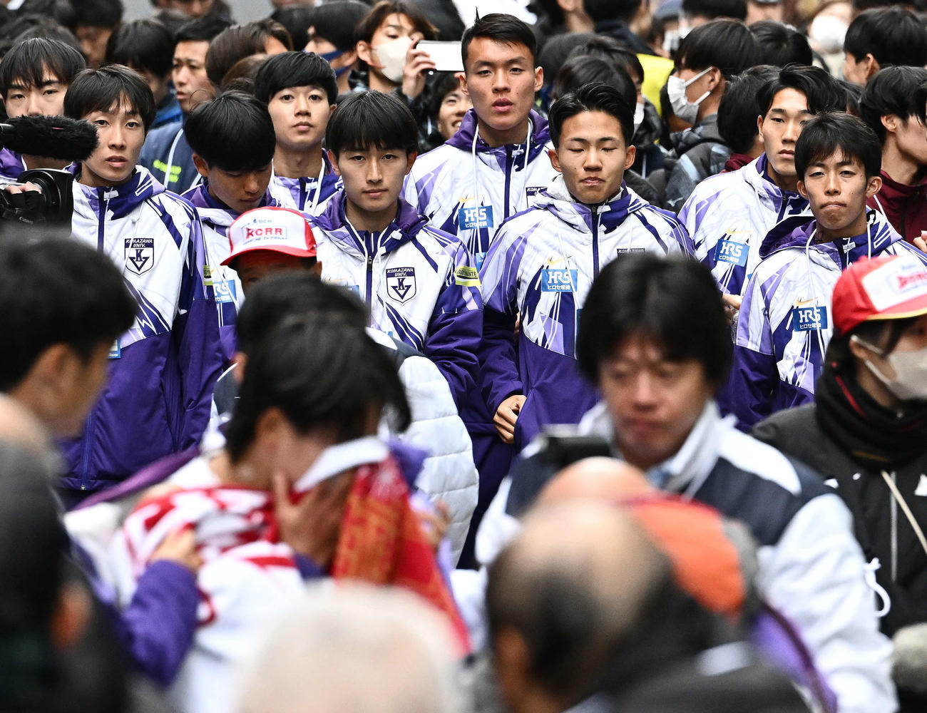 ゴールしタオルで顔を覆う駒大10区庭瀬（手前）を見守る選手たち（撮影・滝沢徹郎）