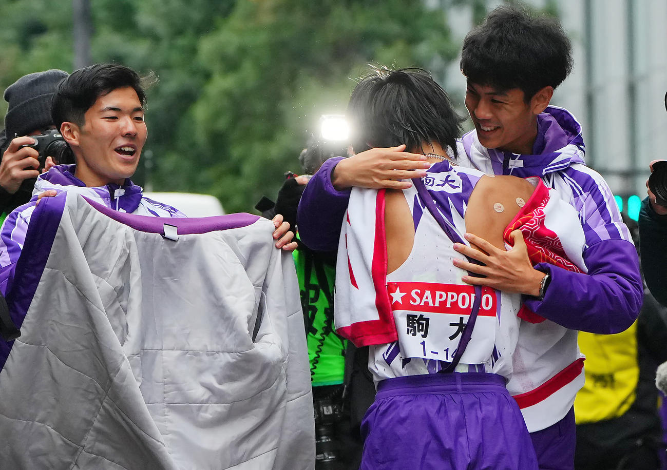 ゴールした駒大10区庭瀬（中央）を笑顔で出迎える鈴木（右）（撮影・垰建太）