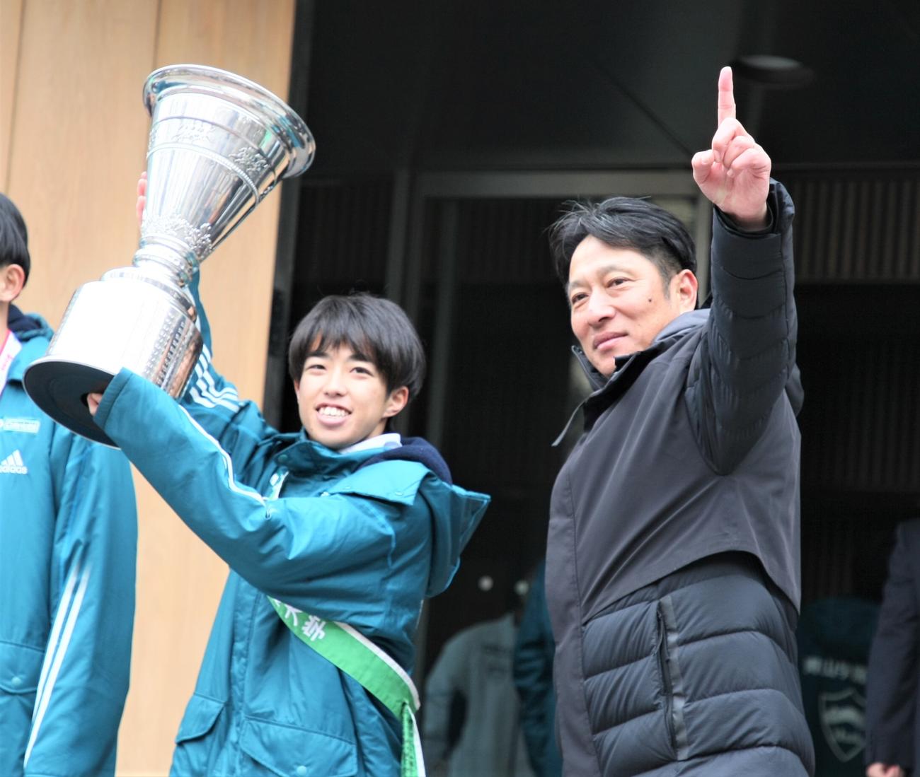 箱根駅伝優勝報告会でトロフィーを掲げる志貴主将（左）とガッツポーズの原晋監督（撮影・藤塚大輔）