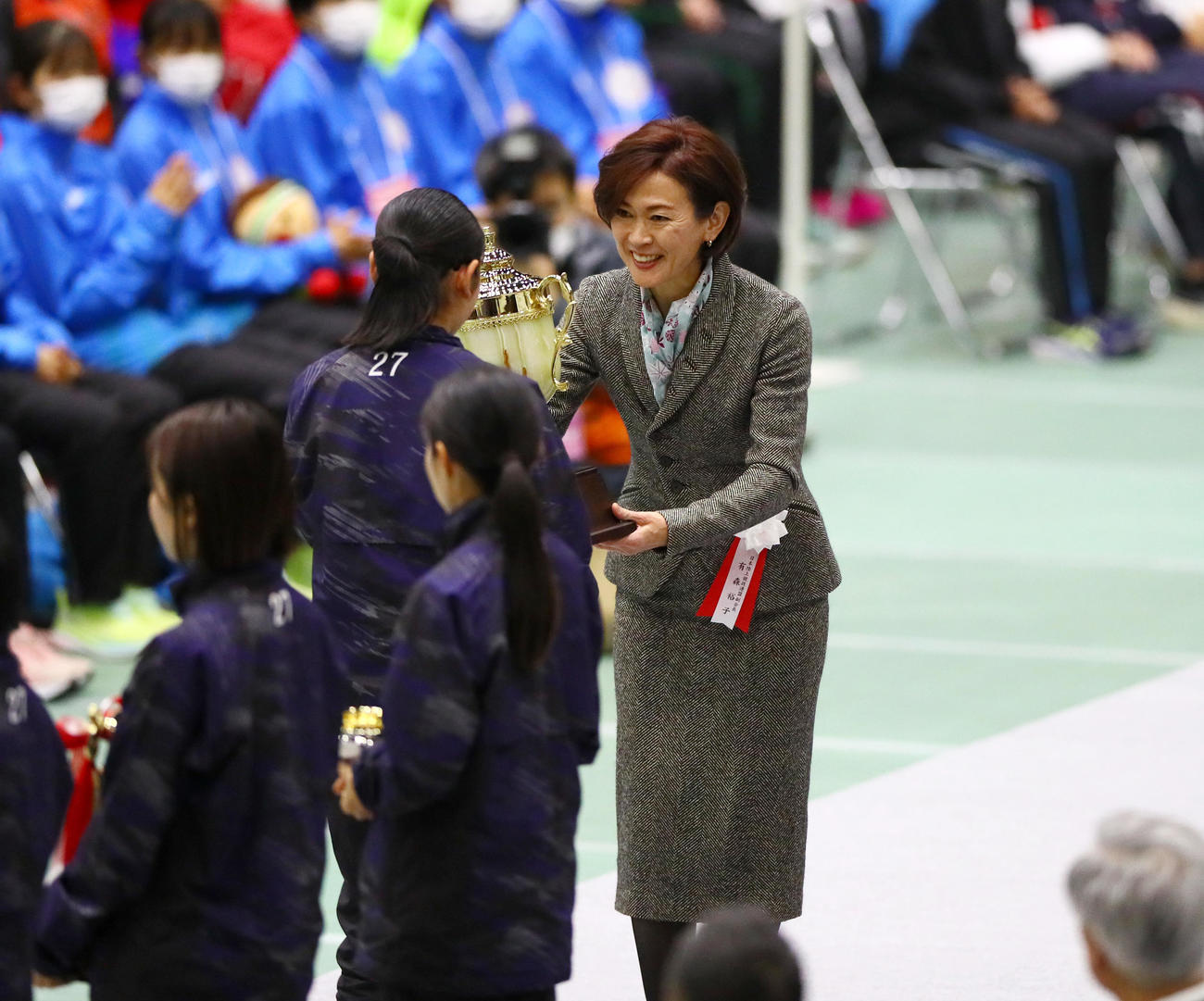開会式で前回優勝の大阪府代表チームにレプリカトロフィーを渡す日本陸上競技連盟副会長の有森裕子氏（撮影・上山淳一）