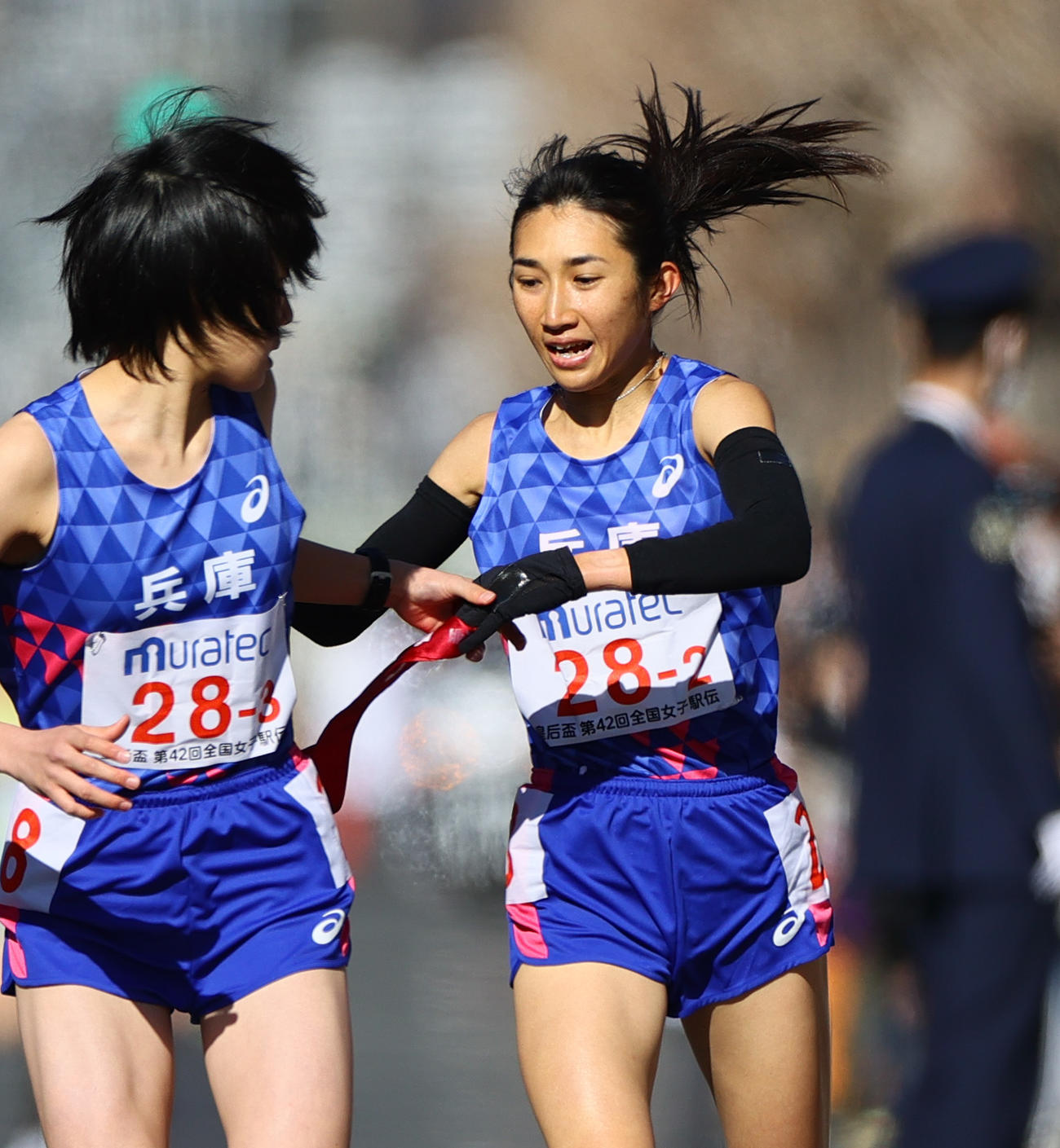 第2中継所の烏丸鞍馬口で兵庫3区藤田莉沙（手前）にたすきをつなぐ2区の田中希実（撮影・上山淳一）